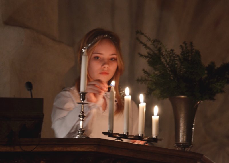 Kleines Mädchen zündet Kerzen in der Kirche an