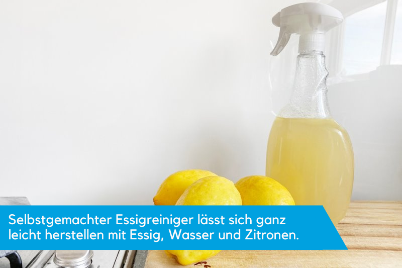 Eine Sprühflasche mit gelber Flüssigkeit und Zitronen davor